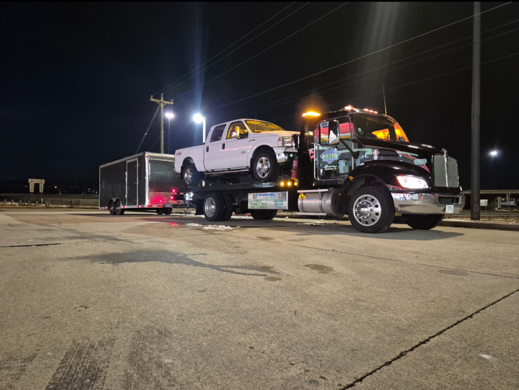 Tow truck carrying white truck and trailer | Yates Wrecker